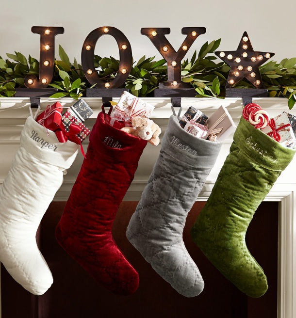 Christmas Stockings, red, white, silver & green hanging at fireplace mantle from holders spelling JOY